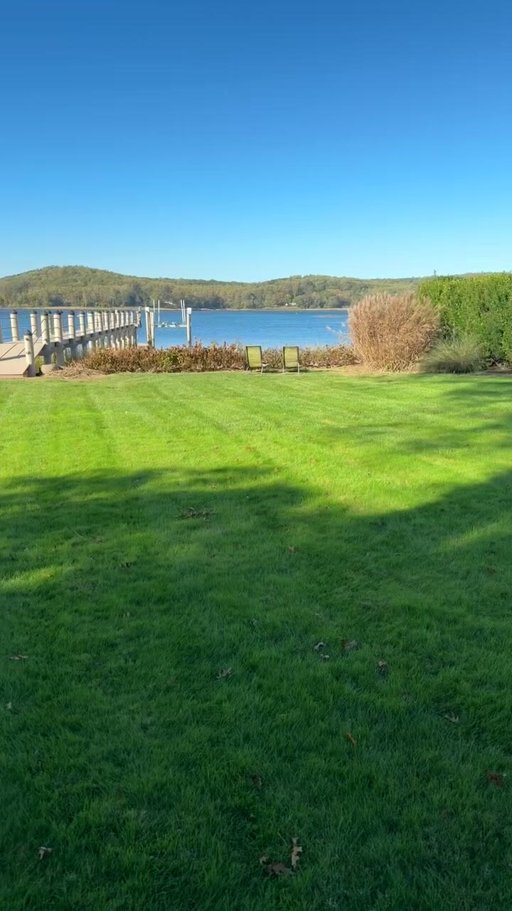 Waterfront property with manicured lawn leading to a dock on the bay.