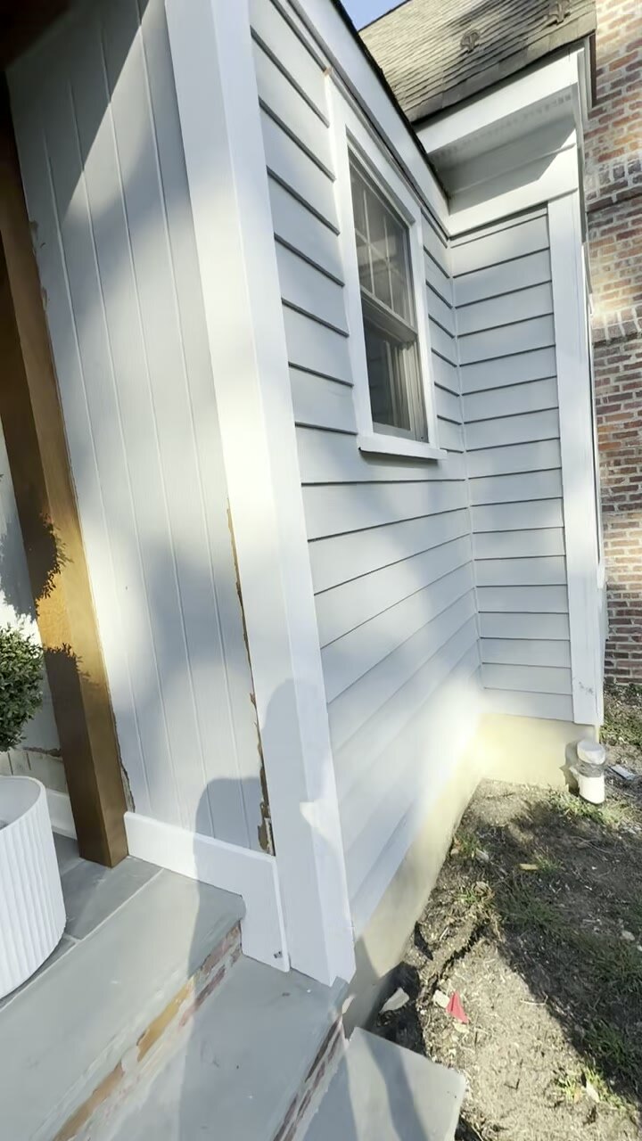 Crisp gray lap siding with white-trimmed window on a finished home.